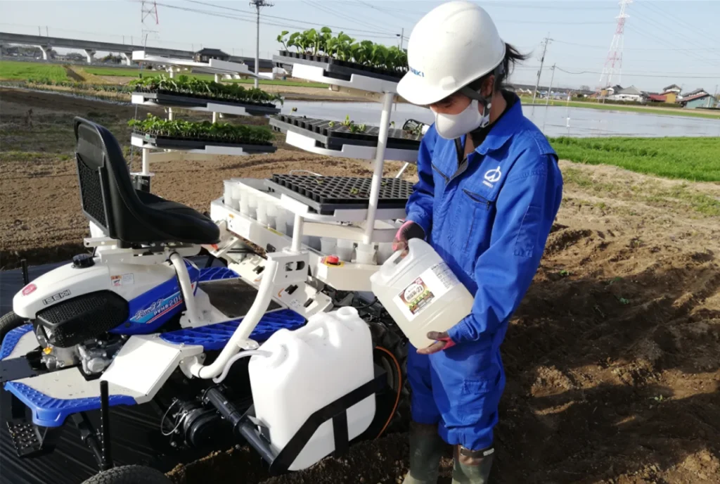 移植機の潅水装置内の水に納豆菌の力を混ぜて希釈液を作っている画像。移植と同時に施用できる